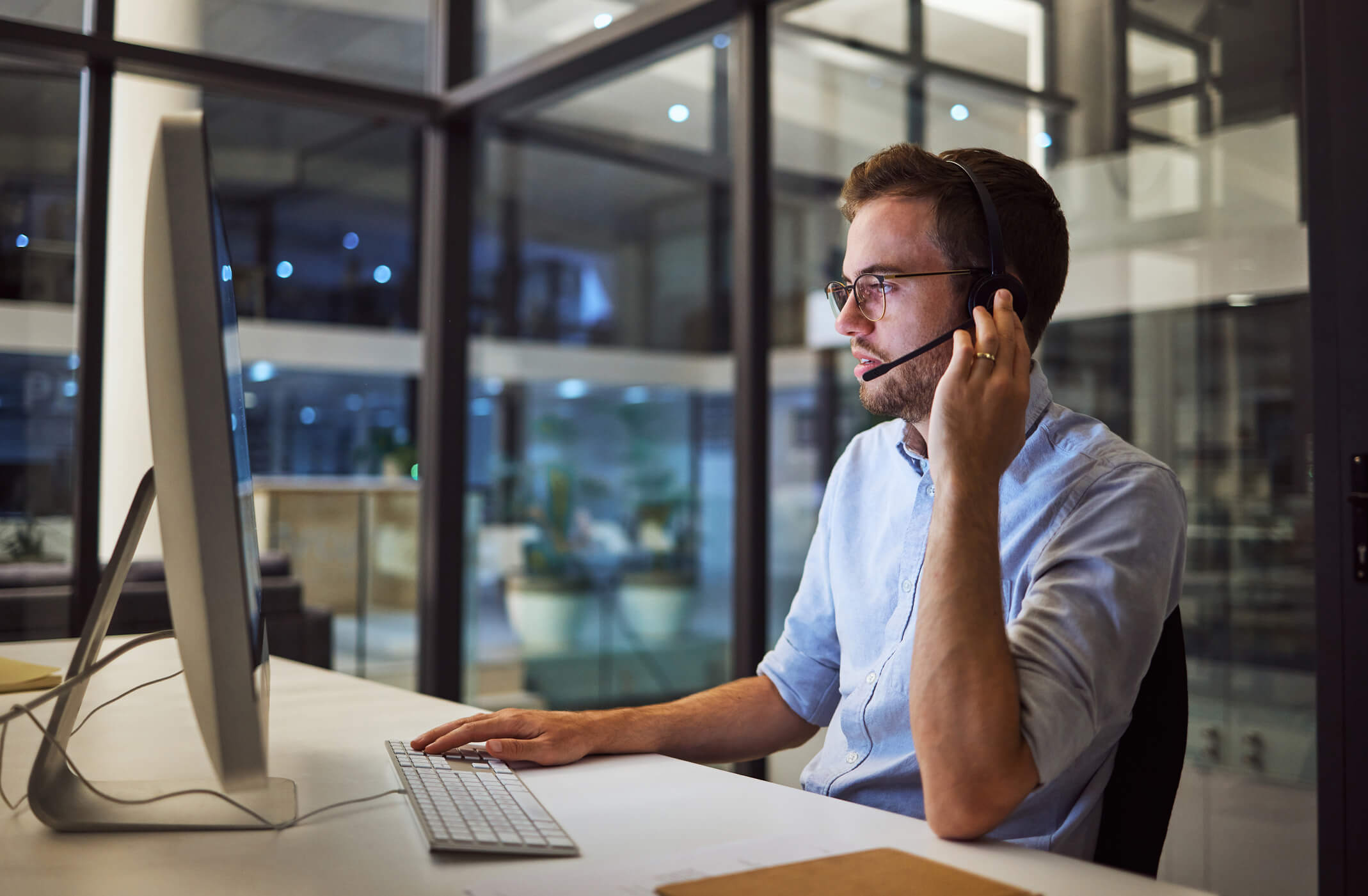 A man working in costumer support solving problems for clients over a call.